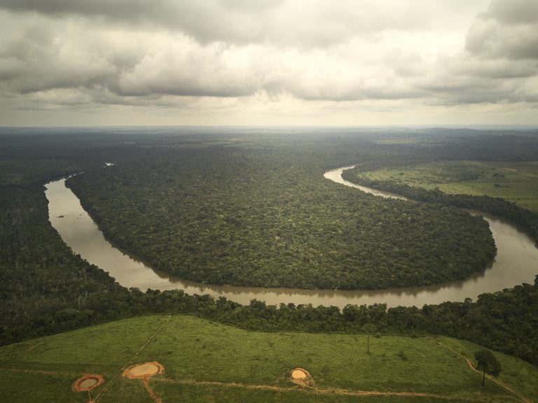 Visão aérea de um trecho no rio dos Peixes onde se pode ver o contraste entre a área desmatada na margem não indígena do rio e a área preservada dentro da Terra Indígena na outra margem. Image by: Pablo Albarenga. Brazil, 2019. Visão aérea de um trecho no rio dos Peixes onde se pode ver o contraste entre a área desmatada na margem não indígena do rio e a área preservada dentro da Terra Indígena na outra margem. Image by: Pablo Albarenga. Brazil, 2019.