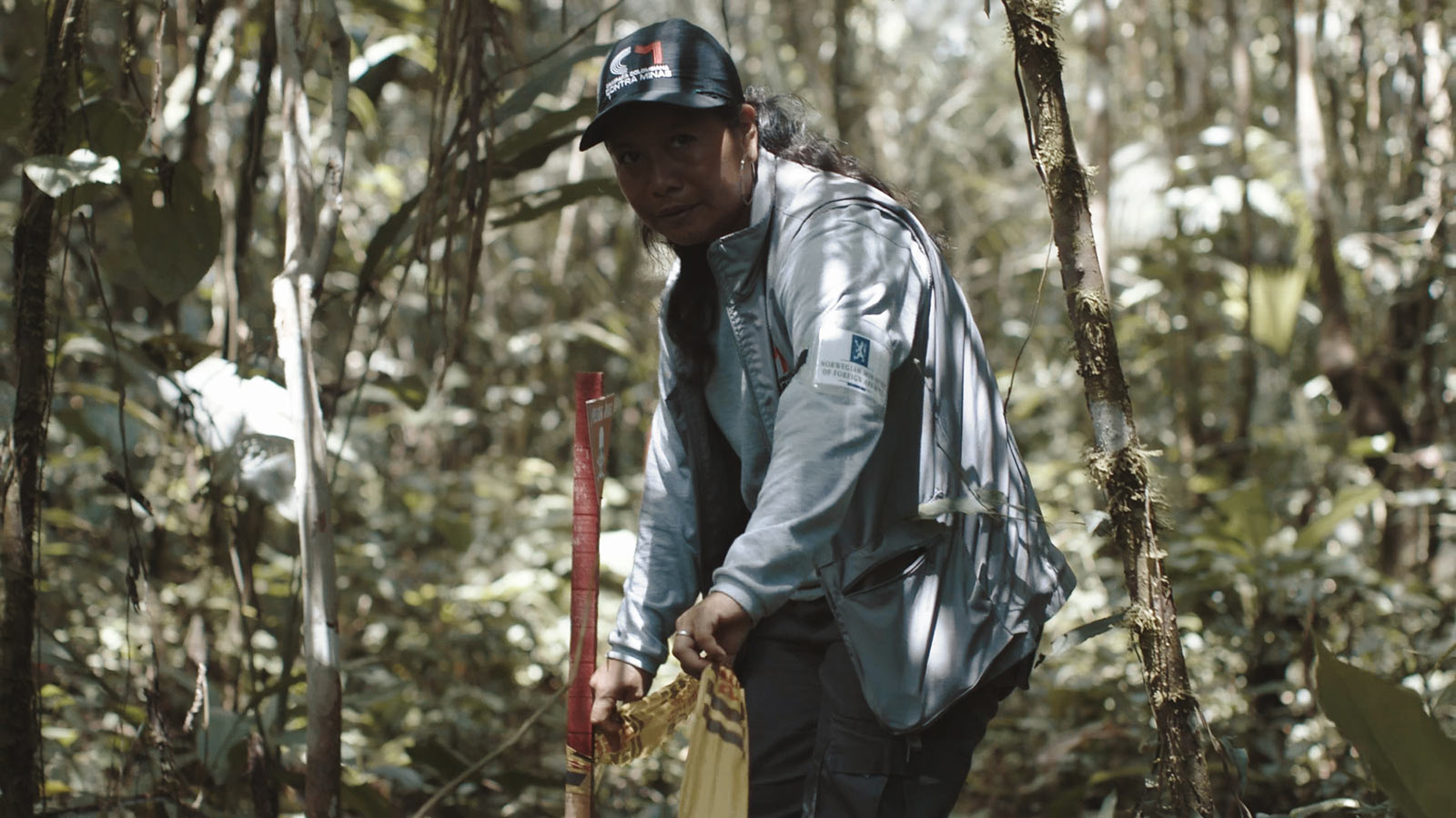 Siona leader Adiela Mera Paz tapes off an area suspected of landmine contamination as part of her work for The Colombian Campaign Against Landmines in Siona territory in December 2019. A still from the New Yorker film “SIONA: Amazon’s Defender’s Under Threat.” Image by Tom Laffay. Colombia, 2019. Siona leader Adiela Mera Paz tapes off an area suspected of landmine contamination as part of her work for The Colombian Campaign Against Landmines in Siona territory in December 2019. A still from the New Yorker film “SIONA: Amazon’s Defender’s Under Threat.” Image by Tom Laffay. Colombia, 2019.