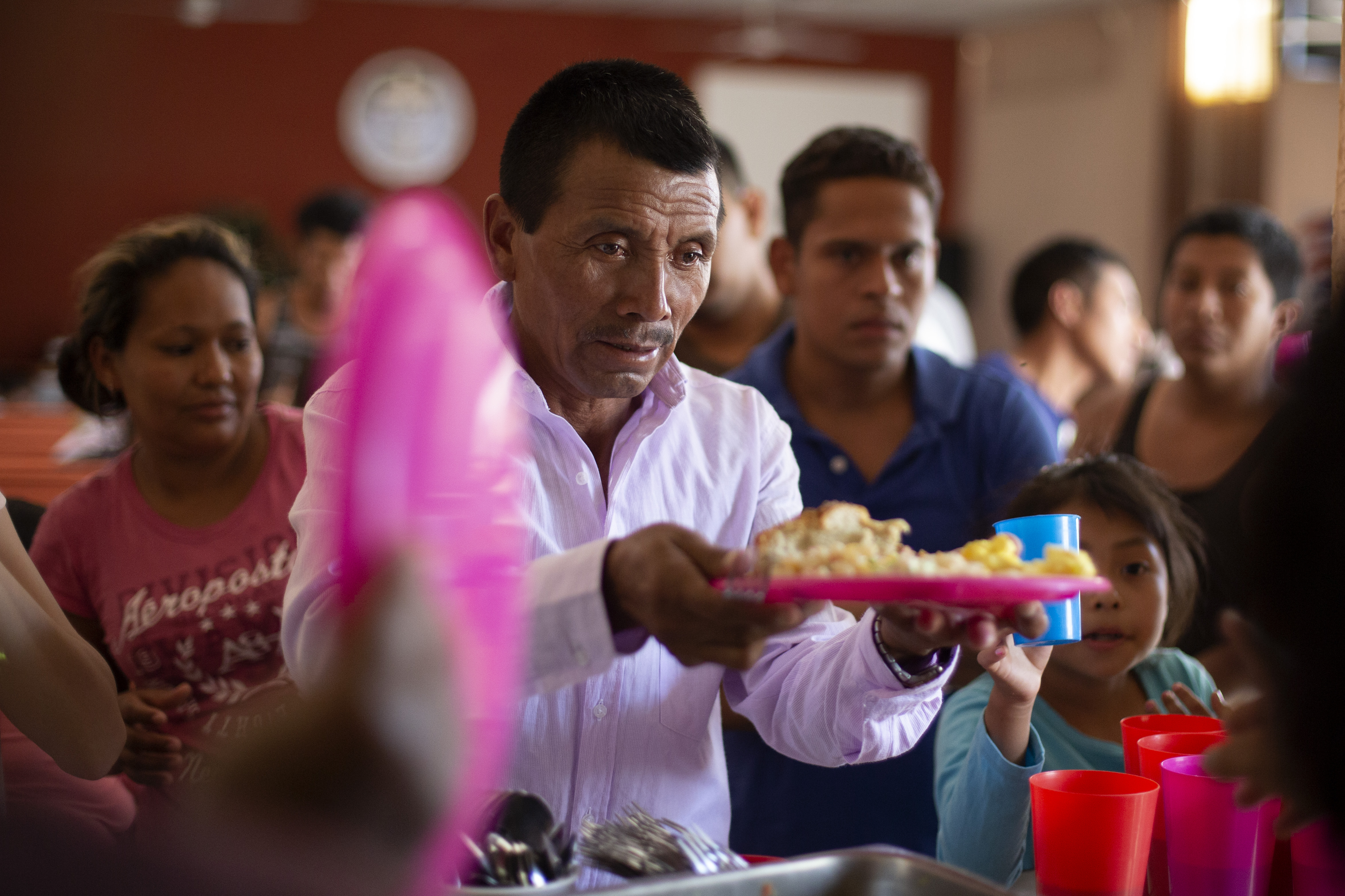 In this July 25, 2019, photo, a Guatemalan man gets a plate of food at El Buen Pastor shelter for migrants in Cuidad Juarez, Mexico. Image by Gregory Bull. Mexico, 2019. In this July 25, 2019, photo, a Guatemalan man gets a plate of food at El Buen Pastor shelter for migrants in Cuidad Juarez, Mexico. Image by Gregory Bull. Mexico, 2019.