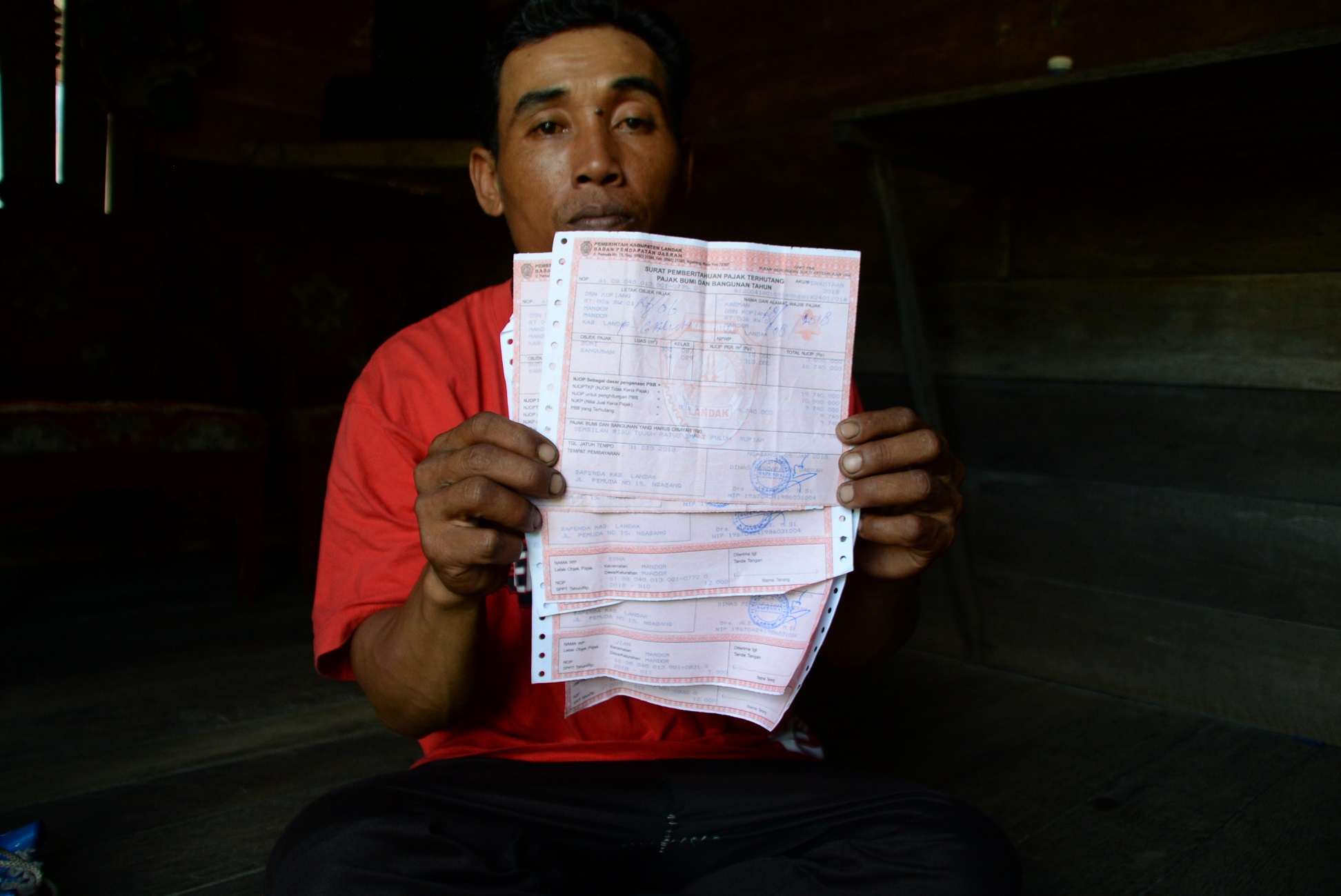 Bukti-Pajak.jpg Abdul Hadi, Ketua RT Dusun Kopiang memperlihatkan Surat Pemberitahuan Pajak Terhutang (SPPT) Pajak Bumi dan Bangunan (PBB).