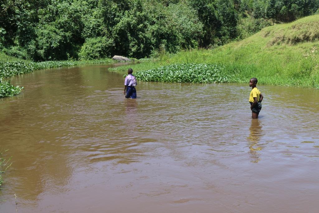 Two children standing in the Rwizi River