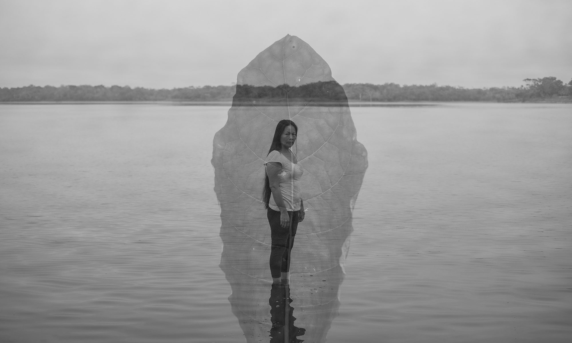 Imagem de Florence Goupil. Foto de dupla exposição em preto e branco de uma mulher em pé diante de um corpo de água com uma folha sobreposta à imagem.