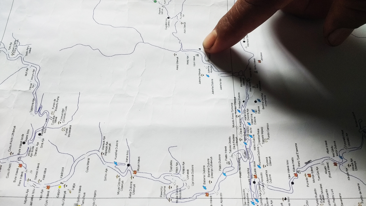 Someone points to a dot on a map.