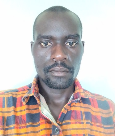 A man with an orange shirt stares into the camera