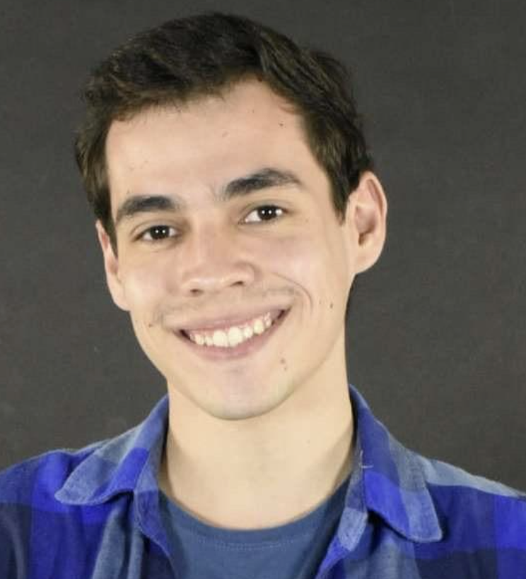 A person with short hair and wears a blue flannel shirt.