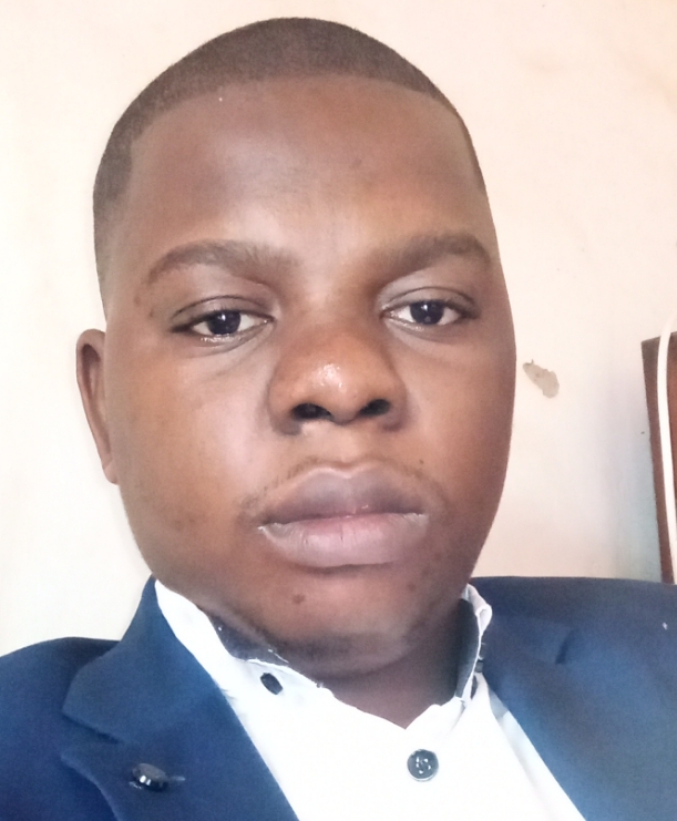 A man with a grey suit, tie, and a white shirt.
