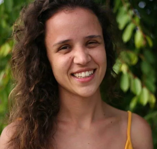A WOMAN SMILES INTO THE CAMERA
