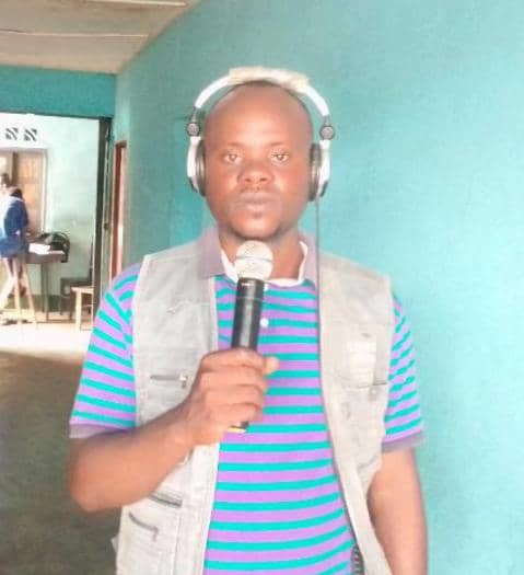 A man wearing headphone is holding a mic.