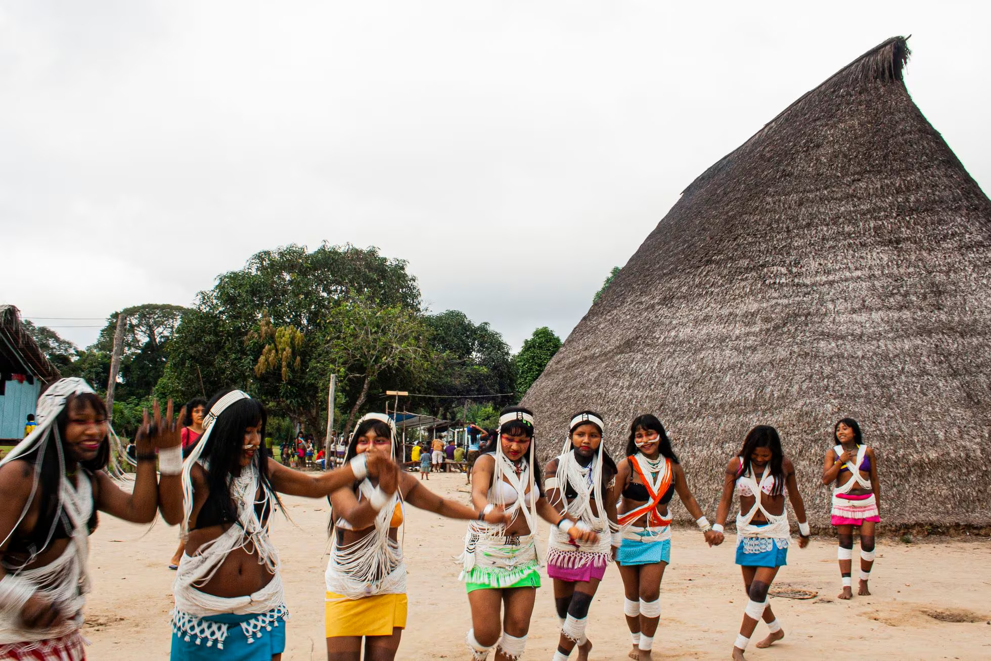 Indigenous girls dance happily in their colourful, traditional attires.