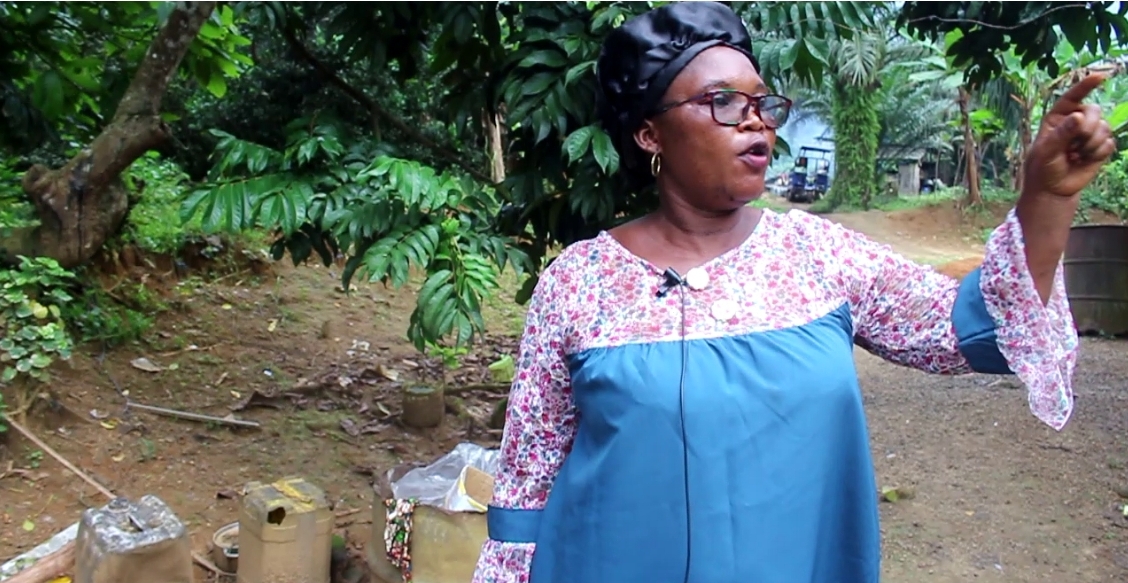 A woman in blue dress points to her left.