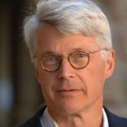 headshot of man in round glasses and suit