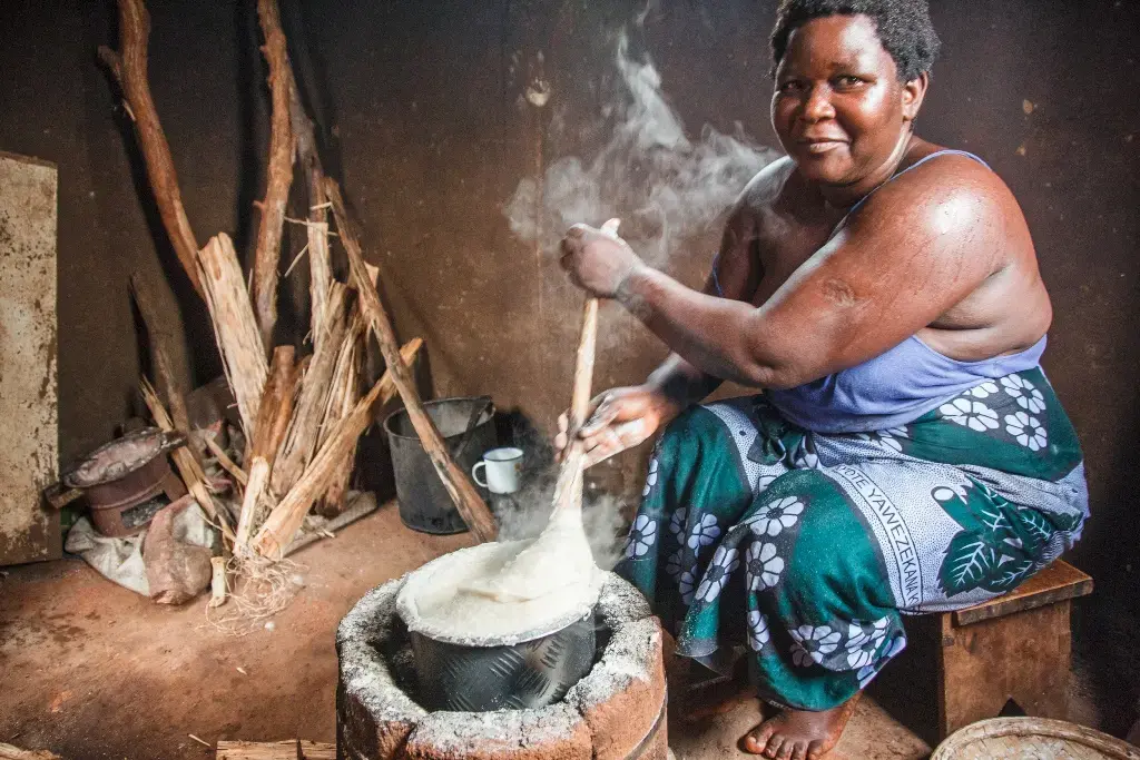 Rose Kandodo is cooking nsima, a maize porridge, on an improved cook stove in Nessa village. Image by Nathalie Bertrams. Malawi, 2016.