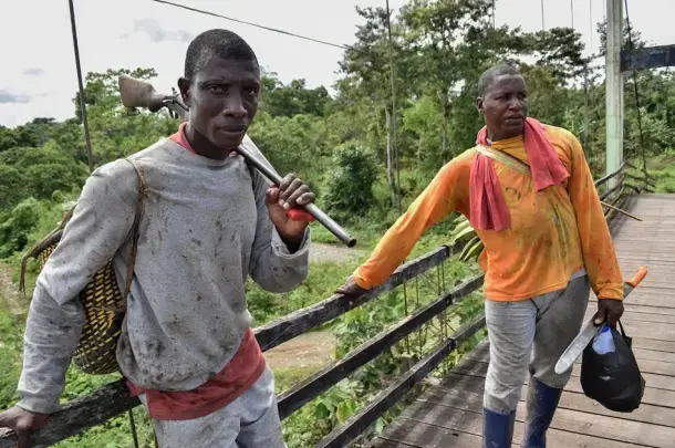 Dos trabajadores afroesmeraldeños en el norte de Esmeraldas. La palma africana domina la gran agroindustria en la región, con grandes capitales; pero la vida de la gente pobre no ha cambiado. Image by Rodolfo Ansar. Ecuador, 2019.
