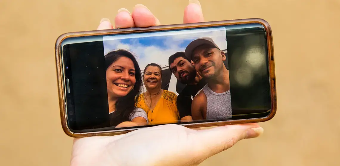Diana Zuñiga holds up a family photo taken at Terminal Island federal prison the day Carlos's dad was released after nearly 10 years in custody, and shortly before he was arrested and taken to Twin Towers Jail. Image by Arlene Mejorado/The Atlantic. United States, undated.