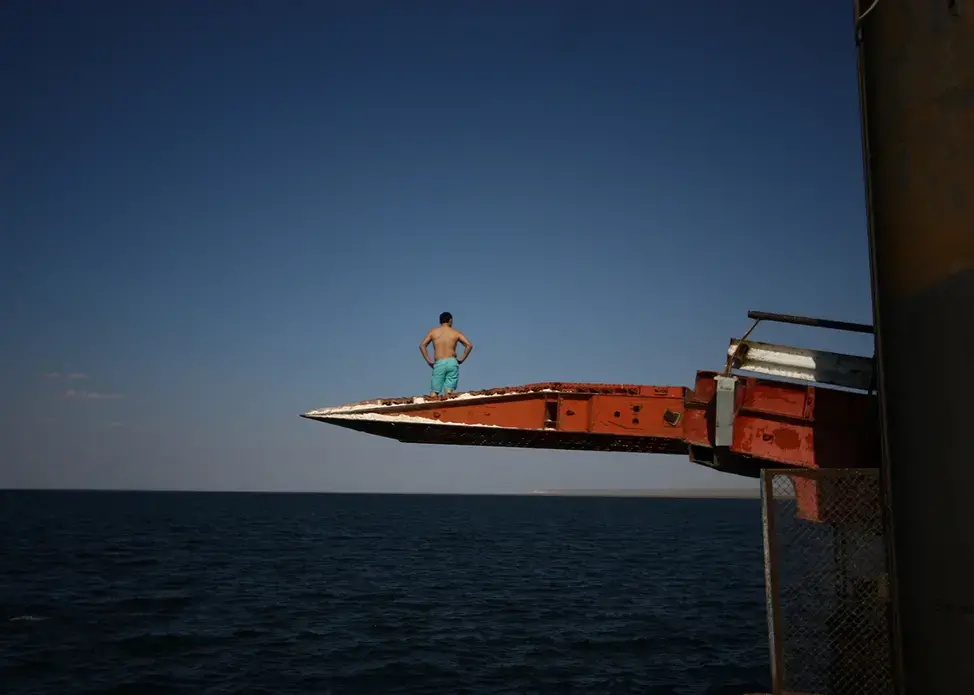 A man prepares to dive off a pier into the Caspian Sea in Sarytas, Kazakhstan, next to the spot where Russian geographers have determined is the true Europe–Asia border. Image by Joshua Kucera. Kazakhstan, 2016.
