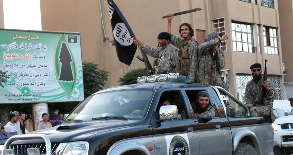 ISIL fighters parade through Raqqa, Syria, in a caravan of Toyota pickup trucks, 2014
