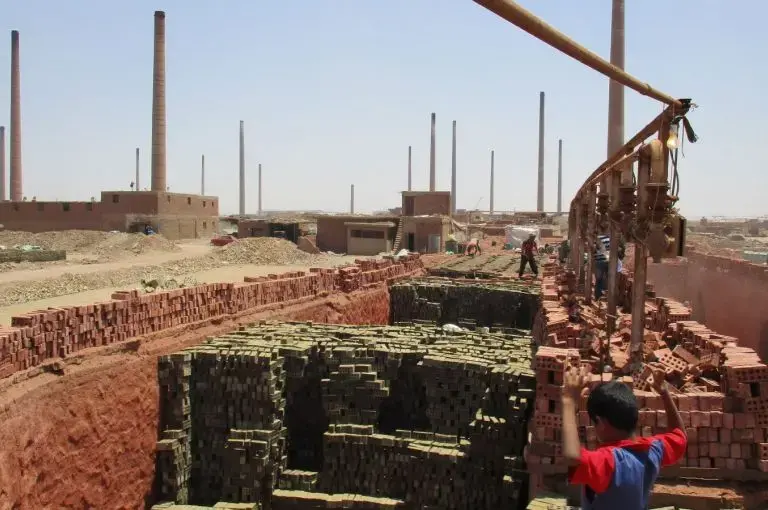 Laborers south of Cairo manufacture bricks to feed Egypt's construction industry. With currency pressures on commodities and real estate, this is one of a handful operating hundreds of factories. Image by Jahd Khalil. Egypt, 2016.