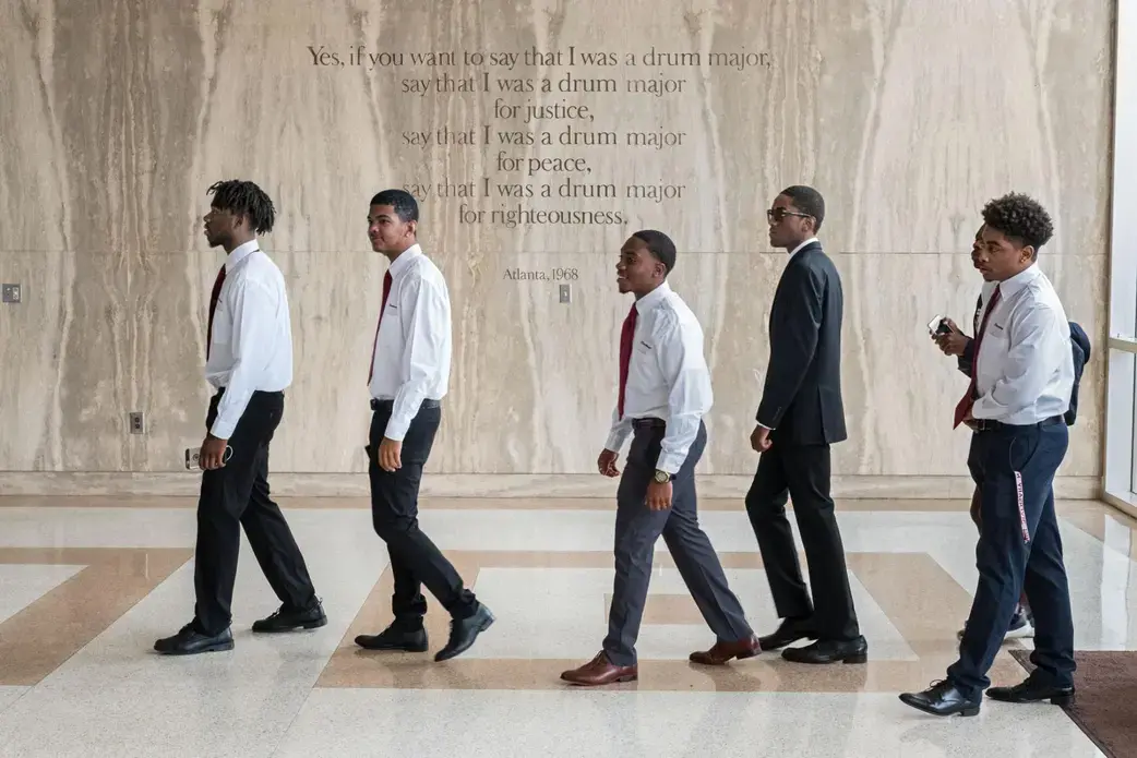 Freshmen enter the Morehouse chapel named for Martin Luther King, Jr., whose words are etched on the wall. The weekly, required Crown Forum assembly introduces leaders who address issues of the day. The all-male college aims to develop disciplined men who will lead lives of scholarship and service. Image by Radcliffe "Ruddy" Roye. United States, 2017.