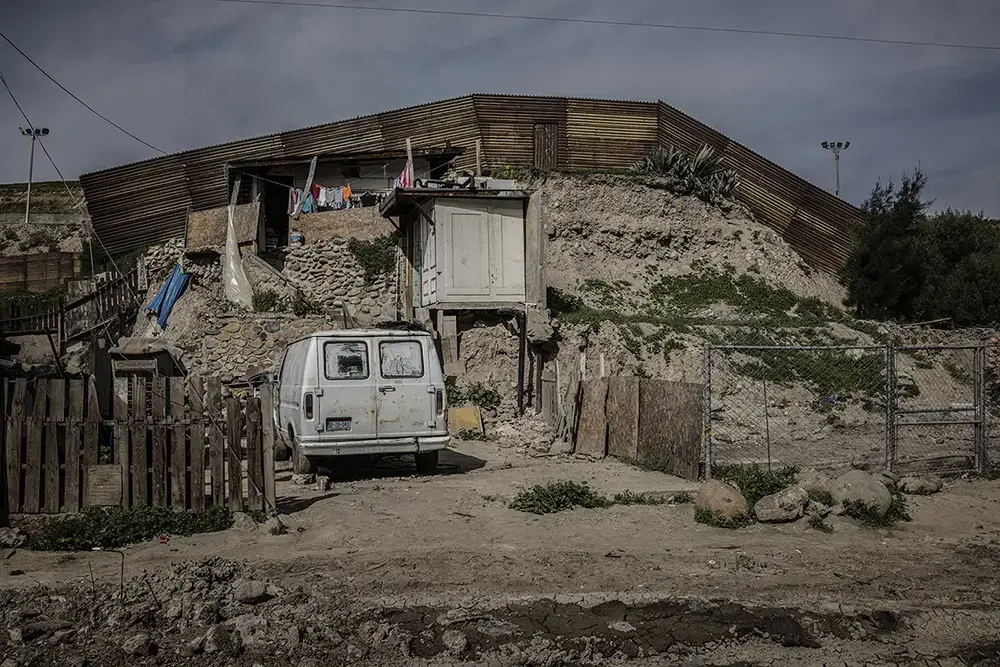 A makeshift house that sits right up against the border wall in Otay Canyon in Tijuana. Image by James Whitlow Delano. Mexico, 2017.
