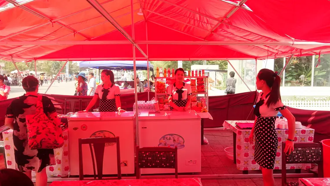 Servers at a snack counter in a tent located outside a cinema in Pyongyang during the Pyongyang International Film Festival. Image by Laya Maheshwari. North Korea, 2016.