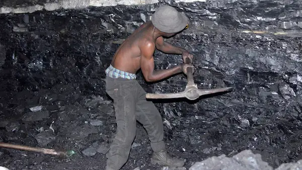A small-scale miner illegally digs coal from an abandoned, former Anker Coal operation just outside Ermelo, Mpumalanga. Image by Mark Olalde. South Africa, 2017.