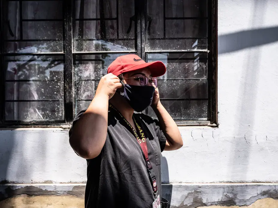 Lady adjusts her makeshift mask before going to her next appointment. Image by Xyza Bacani. Philippines, 2020.