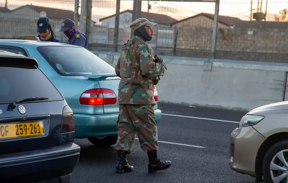 Members of the South African Police Service and the South African National Defence Force deploy at a roadblock on the busy R300 highway. Image by Roger Sedres / Shutterstock. South Africa, 2020.