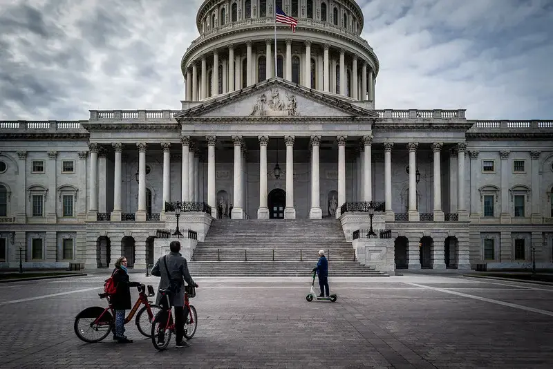 On a day when nearly every museum and landmark was closed due to COVID-19, tourists use rental bikes and scooters to view the outside of the U.S. Capitol. Image by Phil Roeder / Flickr. United States, 2020.