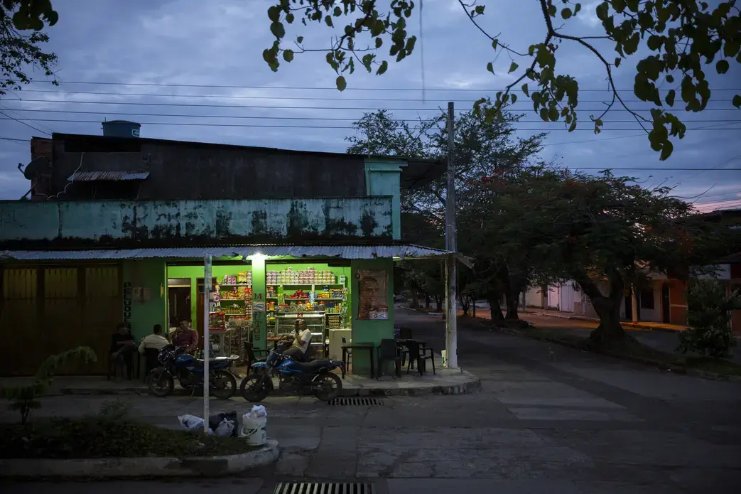 Men enjoy an evening snack at a small shop in Vista Hermosa, Meta, Colombia on Thursday, March 8, 2018. Image by Greg Kendall-Ball. Colombia, 2018.