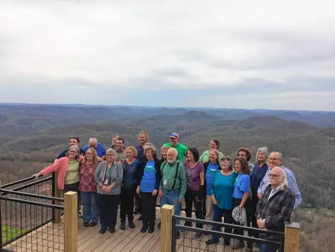 Residents of Leverett and Letcher County, Kentucky pose for a photo together at Hogg Mountain at the end of their four-day visit together. Image by Richie Davis. United States, 2018.