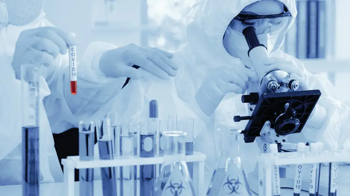 Scientists analyze COVID-19 samples. Image via Shutterstock.