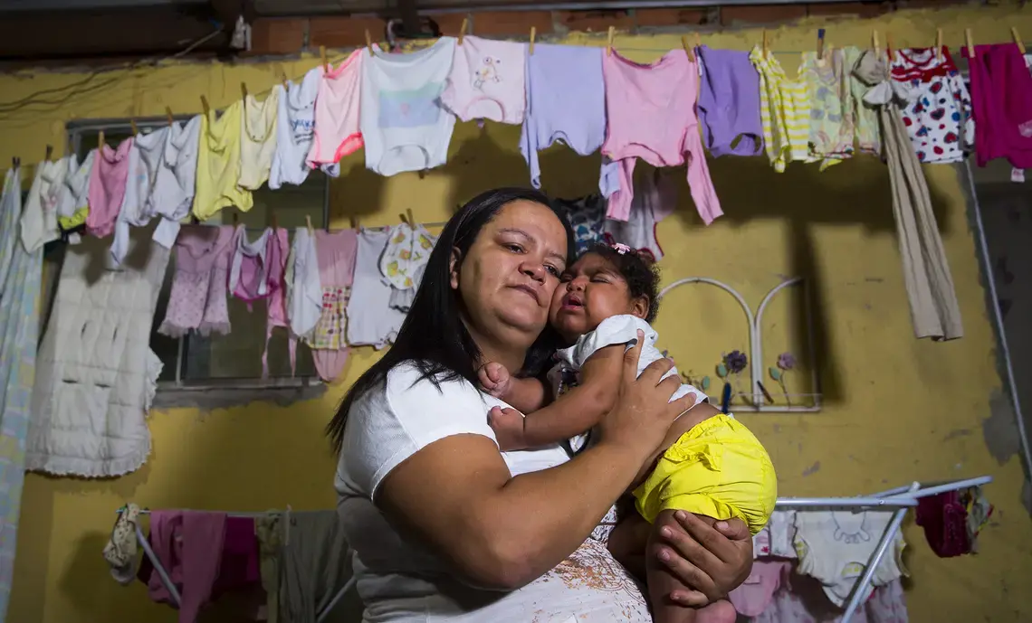 Fabiane Lopes holds her daughter, Valentina at their home in Duque de Caxias, a suburb of Rio de Janeiro in southeastern Brazil. Valentina's mother was pregnant when she became infected with the Zika virus and her daughter was born with microcephaly—a congenital malformation with smaller than normal head size for age and sex as well as other profound birth defects. Brazil has confirmed far more malformations of the brain in babies born to mothers who were infected with Zika than any other country. After…