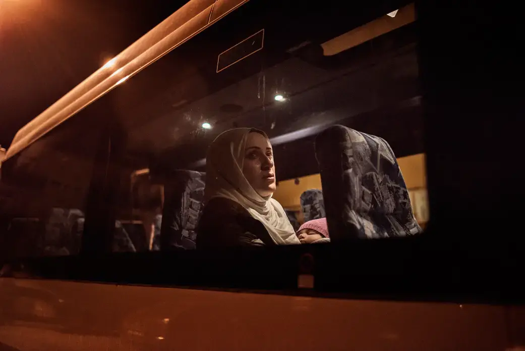 After an exhausting day-long flight, Syrian refugee Taimaa Abazli takes a bus from Talinn, Estonia, to her new home in rural Polva, a village of 6000 people. Photo by Lynsey Addario. Estonia, 2017.