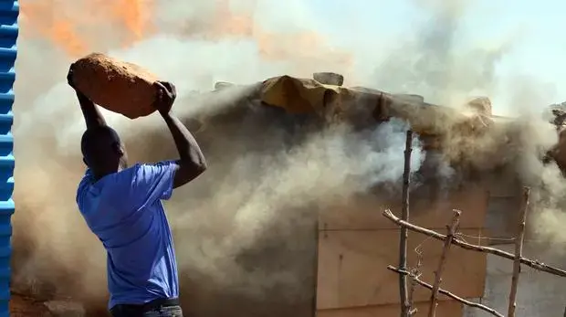 A shack fire breaks out in the Zamimpilo informal settlement. Poor living conditions complicate efforts to link mine waste to health issues. Image by Mark Olalde. South Africa, 2017.