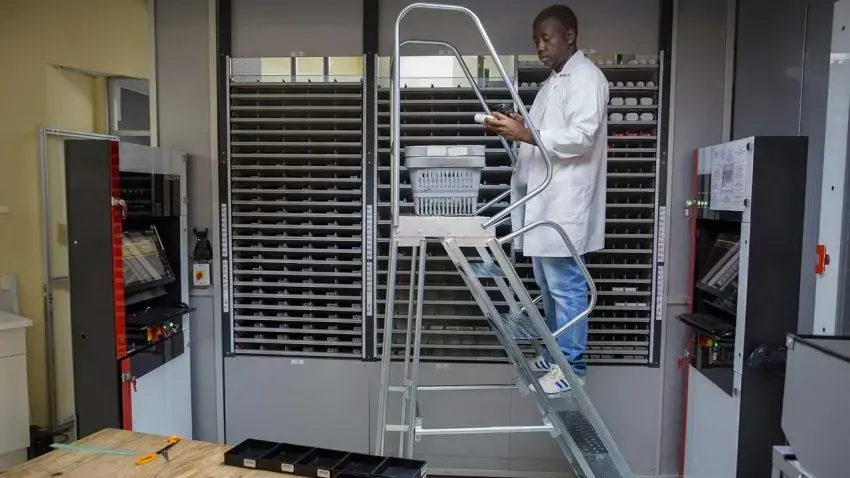 A staffer scans a bottle of pills that he then puts into the back of a Pharmacy Dispensing Unit — an ATM that may one day be in shopping malls.