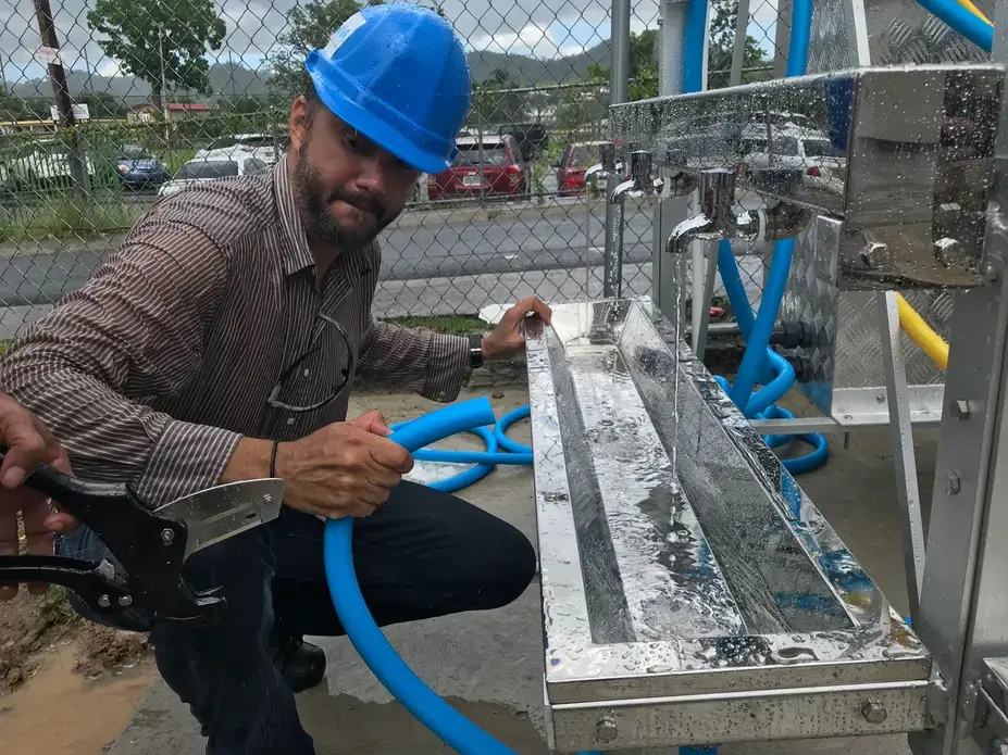 Joachim Alonso, co-founder of Rayo De Luna, makes the finishing touches on a water tower. Image by Tomas Woodall Posada. United States, 2018.
