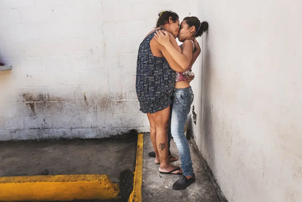 Maria, 35, kisses her daughter during visitation hours at Poli-Valencia, Carabobo. Image by Ana María Arévalo. Venezuela, 2018.