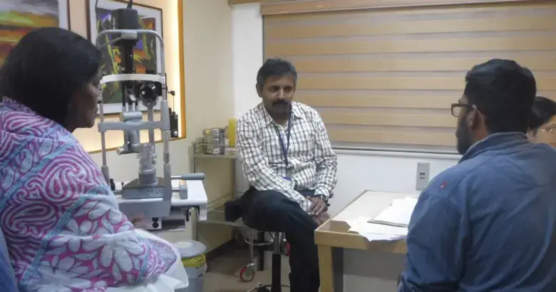 a leading eye specialist at Sankar Nethralaya, interacts with a patient and her son.