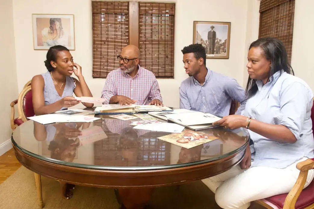 Caroline Washington with her father, Theo, brother Teddy, and mother, Denise as they go through family albums. The family members have been outspoken advocates for education and social justice over many generations. Image by Wiley Price. United States, 2019.