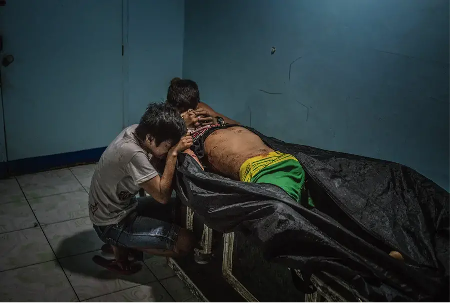 Ginnalyn Soriano and her youngest brother, Jonas, at the morgue with their eldest brother, Julius. Image by James Whitlow Delano. Philippines, 2017.