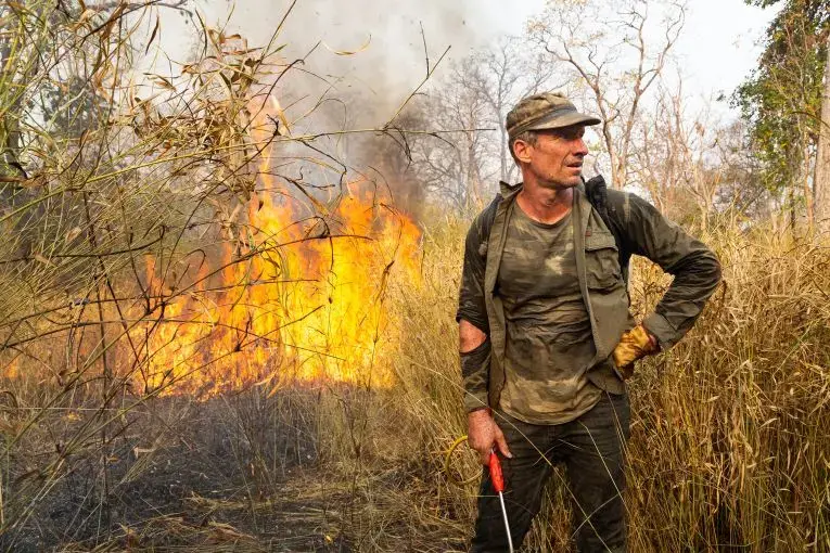 Ben Davis, an independent American conservationist, takes a break from battling a fire in the Phnom Tnout Wildlife Sanctuary, where he lives with his family in northern Cambodia. Fires in the area are lit by farmers, loggers, and local people looking to either capture wildlife or clear land for agriculture. In 2018, fires burnt in record numbers throughout the forests of north and central Cambodia. At their peak during the dry season between January and March, it is estimated up to 1,800 fires were burning…