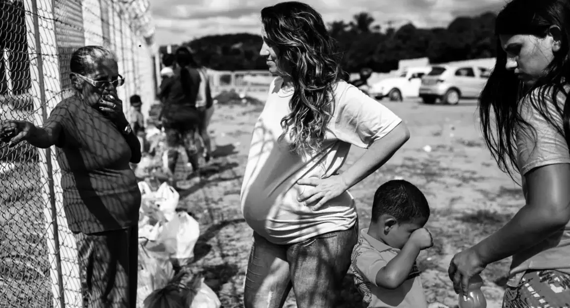 A pregnant woman, who did not want to be identified, waits for the gates to open to visit her boyfriend outside Alcaçuz Federal Penitentiary. Image by Lianne Milton. Brazil, 2018.