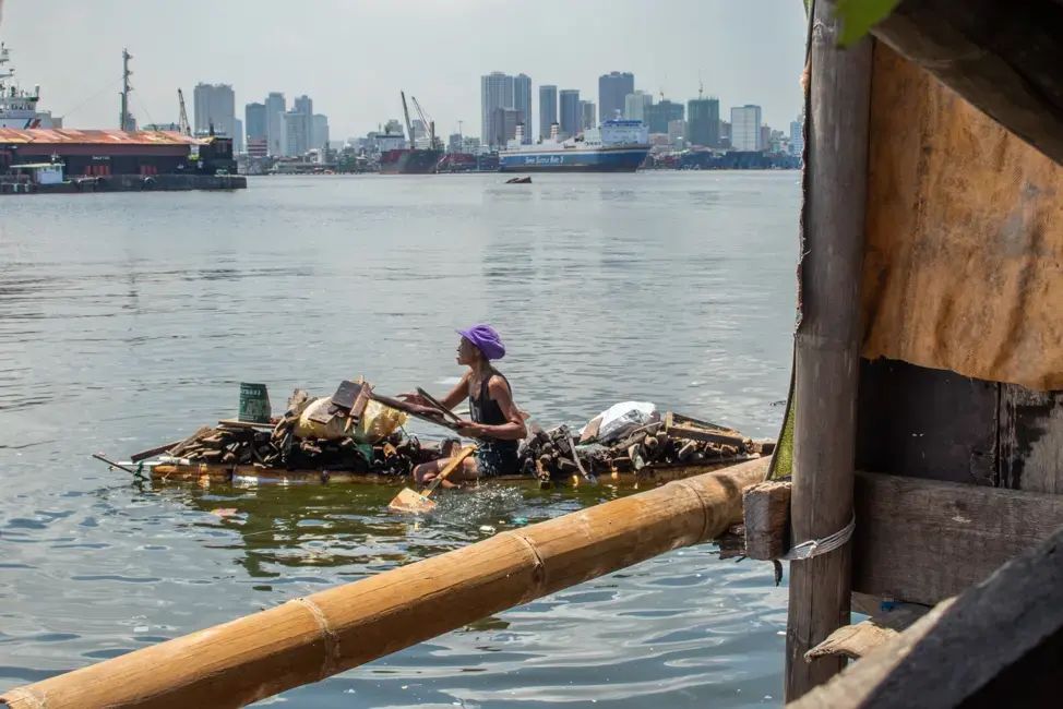 People in Manila create numerous opportunities to make a living for themselves, such as looking for scraps of wood in the bay to make lump charcoal. Image by Micah Castelo. Philippines, 2019.