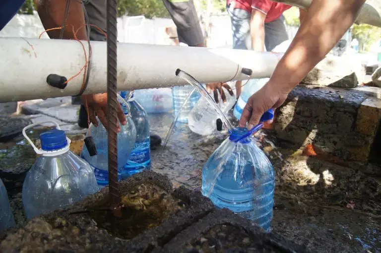 Residents collect water from a makeshift and unregulated water source at Springs Way. Image by Jacqueline Flynn. South Africa, 2018.