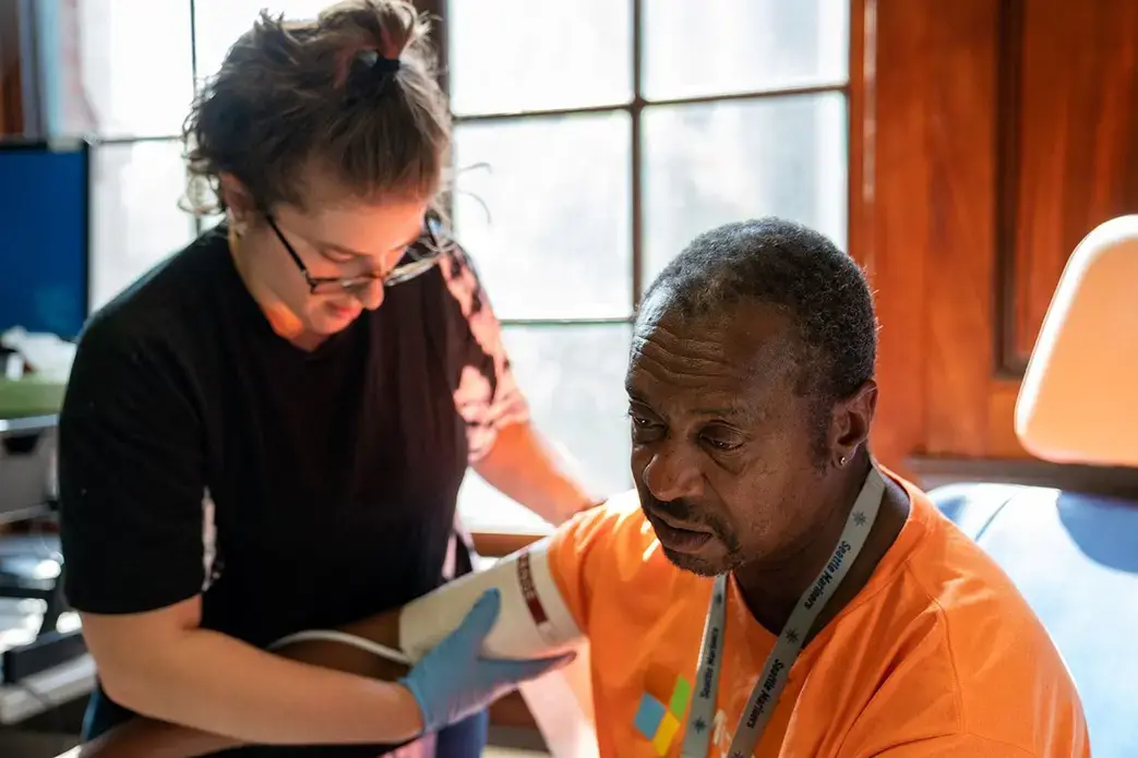 Annie Valenciano, manager of the Downtown Emergency Service Center in Seattle, checks on a client on July 24, 2019. In response to the pandemic, the organization spent nearly $12,000 on smartphones, tablets and laptops so clients could access telehealth services while adhering to shelter-in-place mandates. Image courtesy of Downtown Emergency Service Center. United States, 2019.