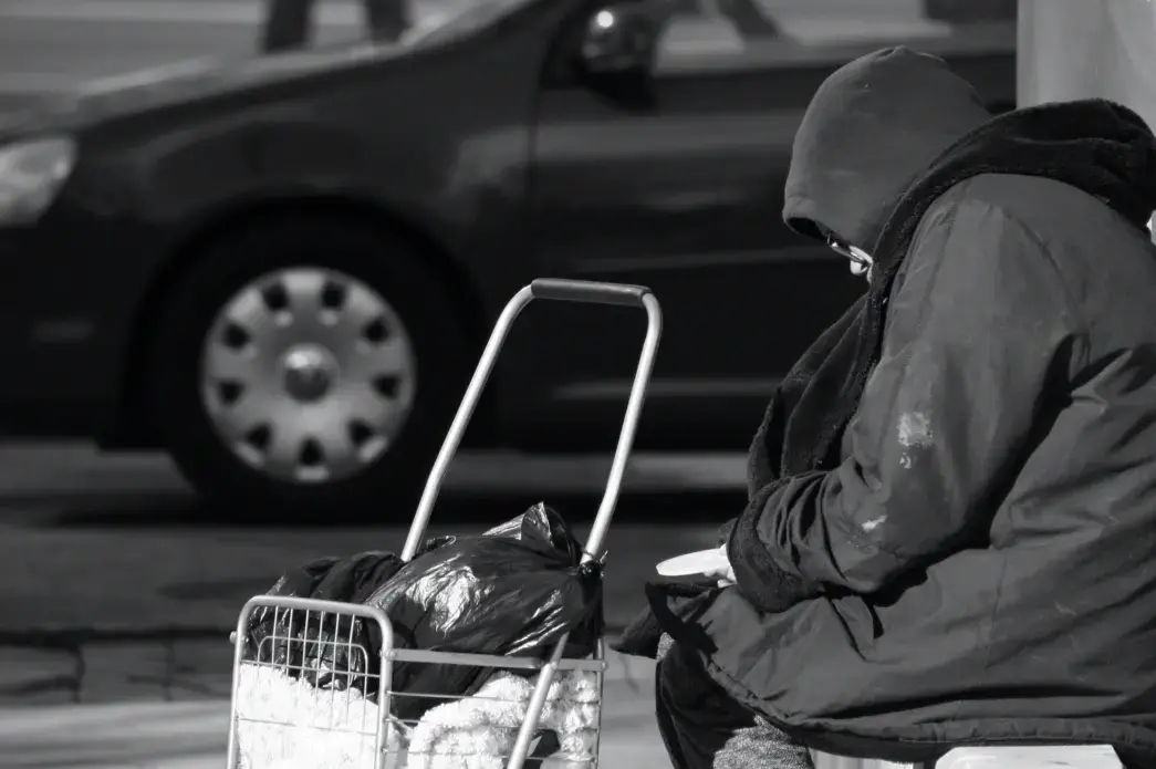 Atlanta, Georgia/United States-January 24 2018: An unidentified homeless person sits on a bench in midtown Atlanta on Peachtree Street. Image by Image Alleviation/Shutterstock. United States, 2018.
