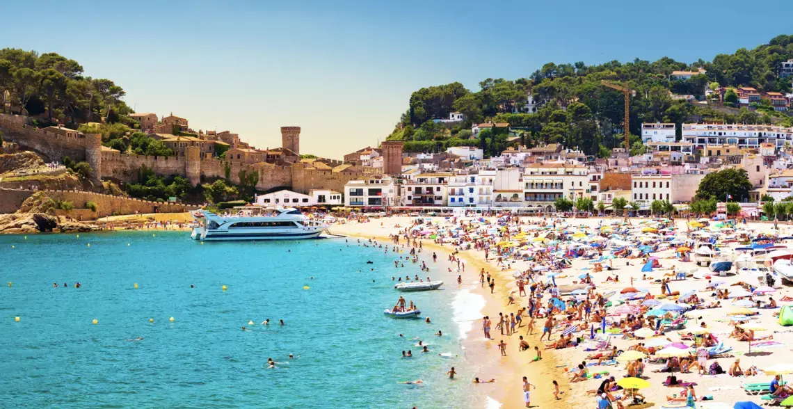 Coast with tanning and bathing people (Panorama of Costa Brava, Tossa de Mar city, Spain). Image by Denis Mironov/Shutterstock. Spain, undated.