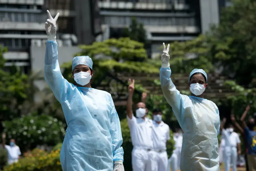 Hospital staff in Mumbai pay tribute to those involved in the fight against the spread of the coronavirus. Image by Manoej Paateel/Shutterstock. India, 2020.
