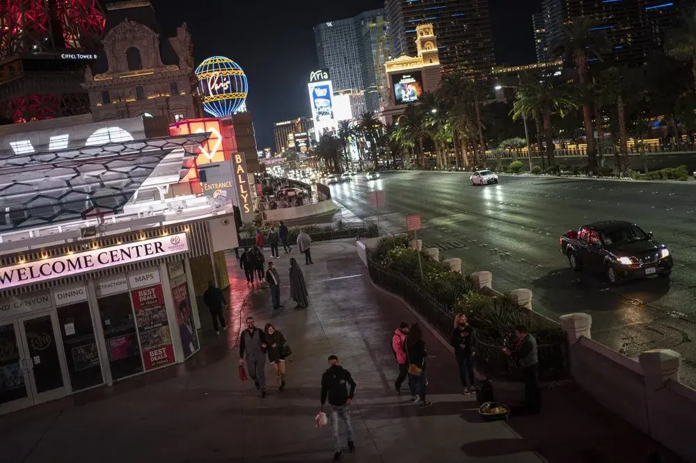 People walk along the Las Vegas Strip, Monday, Nov. 9, 2020. Things have gotten better in Las Vegas since casinos were allowed to reopen in June, following the springtime shutdowns to avoid the spread of the coronavirus. But the number of visitors is still just half of what it was a year ago.&nbsp;Image by Wong Maye-E / AP Photo. United States, 2020.