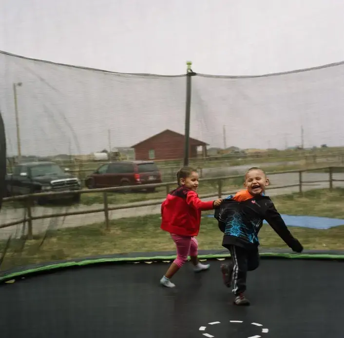 Clarence McNabb’s children play at their home in Browning on Blackfeet Indian Reservation in western Montana. Clarence was working in the oil fields in Williston, North Dakota, and was found dead in 2017. His mother, Ruby Young Running Crane, believes her son was murdered. Image by Sara Hylton. United States, 2019.